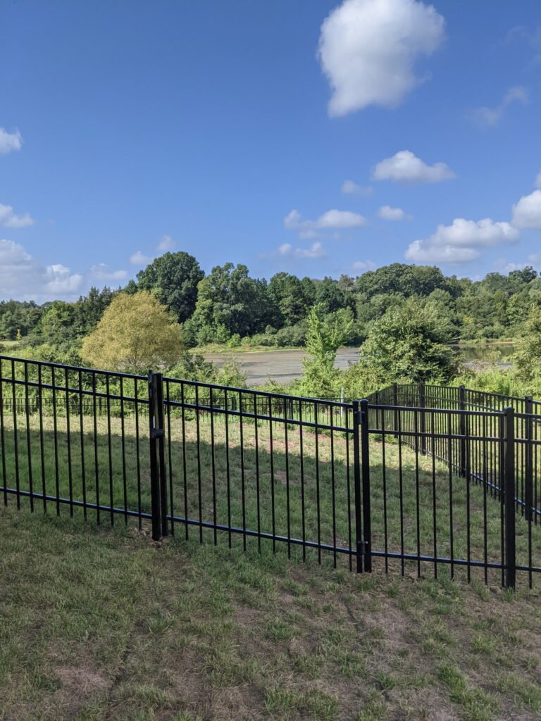black residential aluminum picket fence, surrounding a residential property