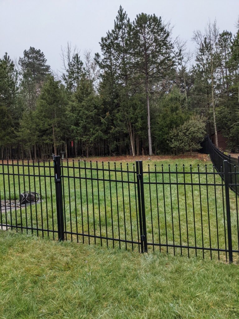 black residential aluminum picket fence, surrounding a residential property