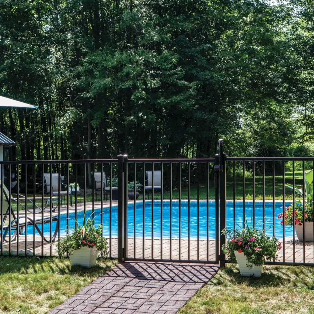 a black aluminum fence in front of a residential pool setting