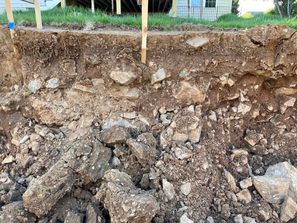 a picture showing rocky terrain underneath a residential yard